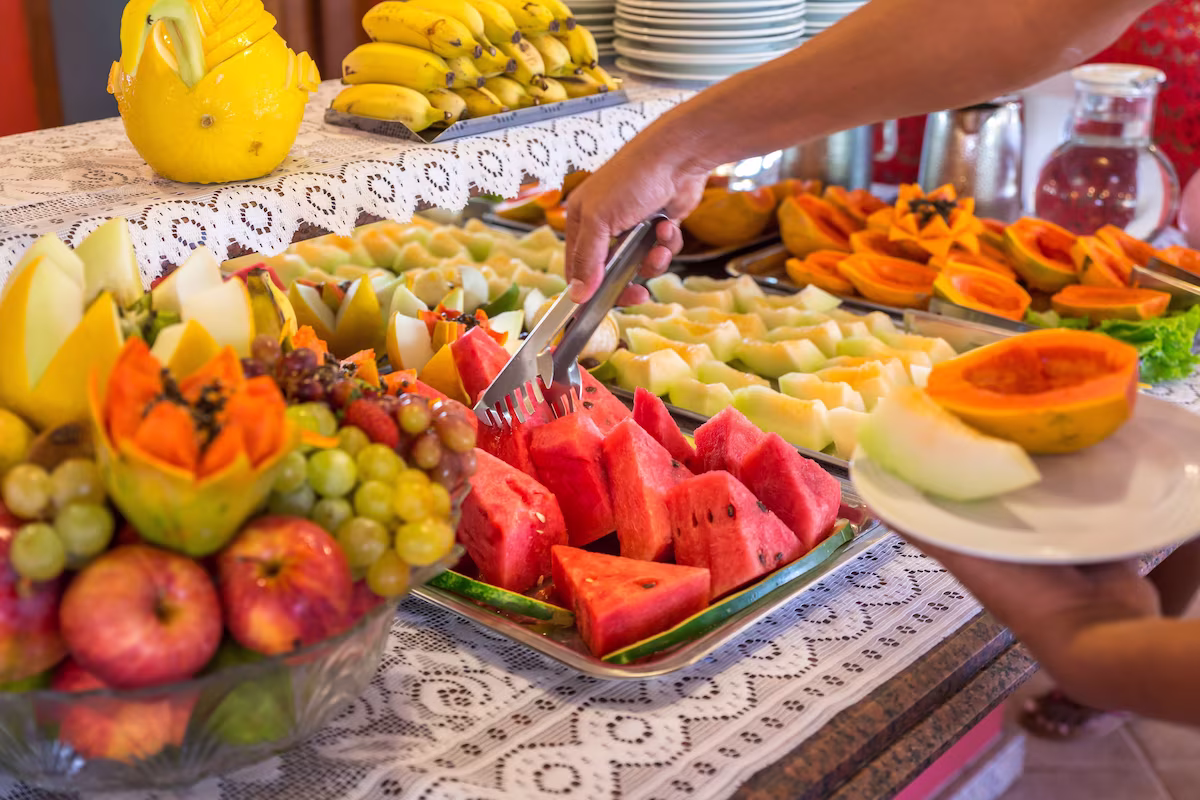 Mesa de café da manhã do Porto Geraes com pães, bolos, frutas e sucos